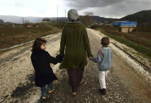 Sawssan  Abdelwahab, who fled Idlib in Syria, walks with her children outside the refugees camp near the Turkish-Syrian border in Yayladagi